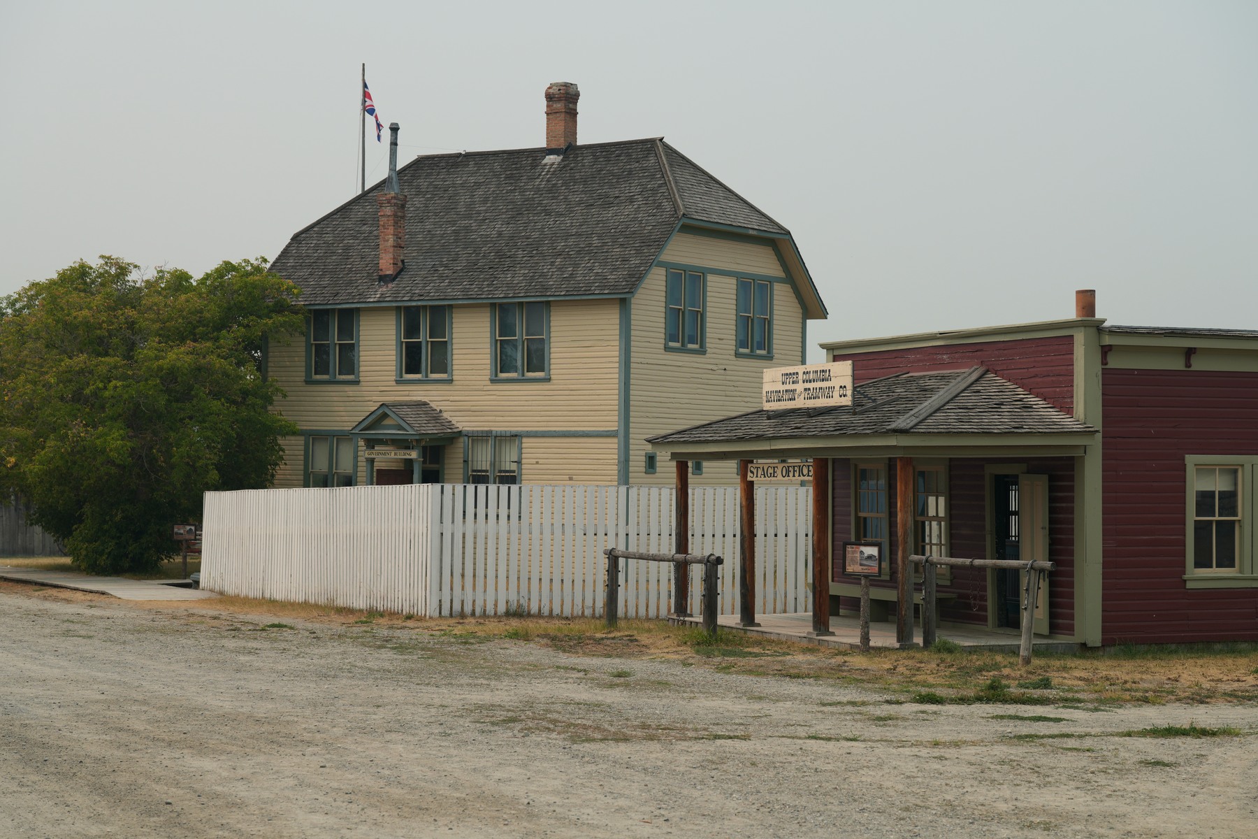 Historic-looking townsite buildings at Fort Steele under a smoke-softened sky
