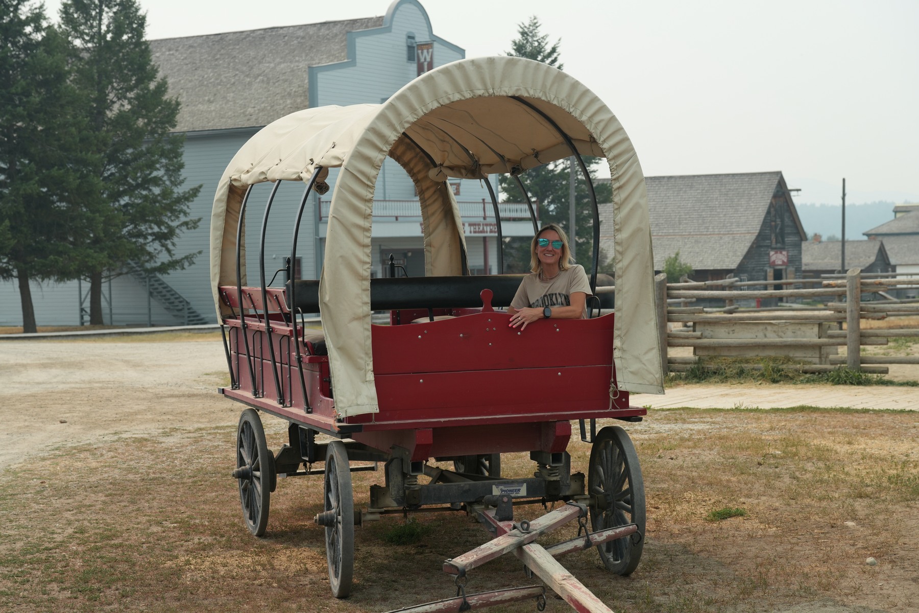 Emilie seated in a covered wagon at Fort Steele